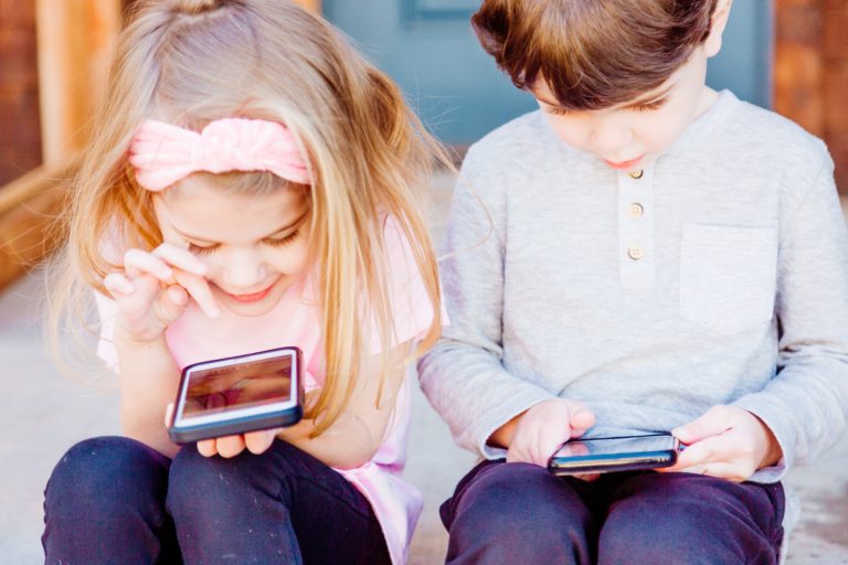 two children looking at the phones